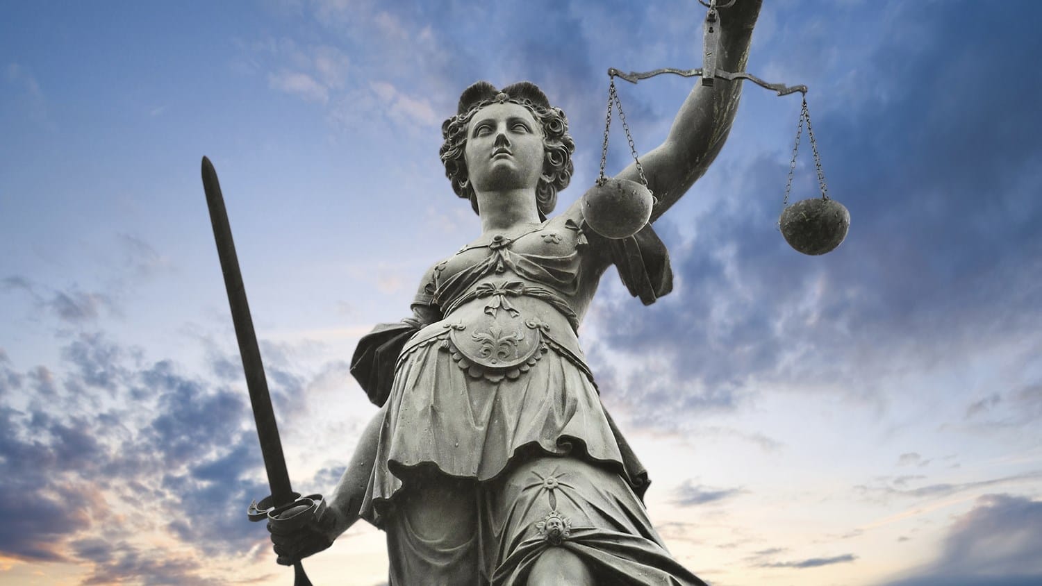 A statue of Lady Justice holding a sword and scales, symbolizing justice and strength.