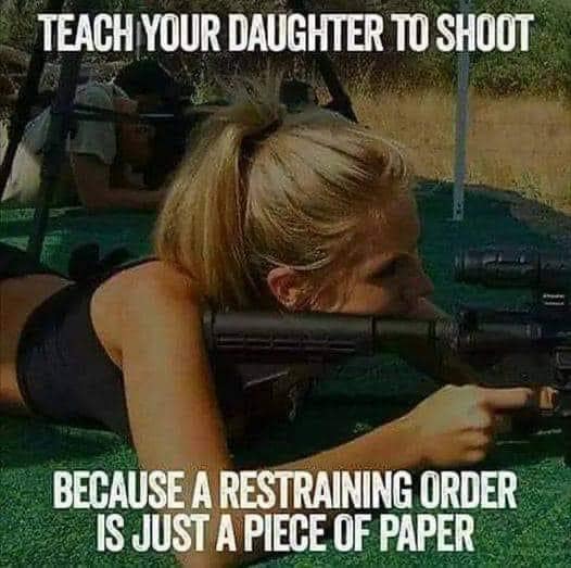 Woman lying down aiming a rifle at a shooting range.