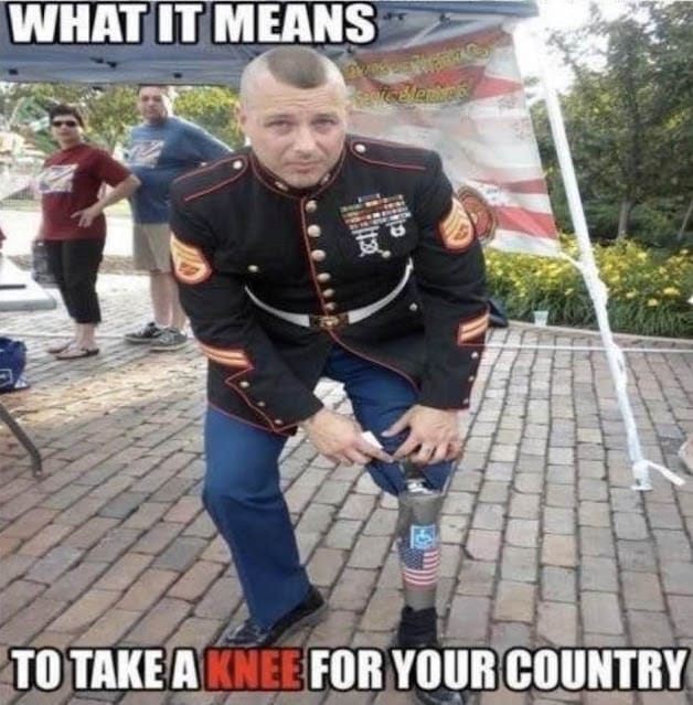 A man in a marine corps uniform with a prosthetic leg takes a knee on pavement, reflecting on the enemies he faced.